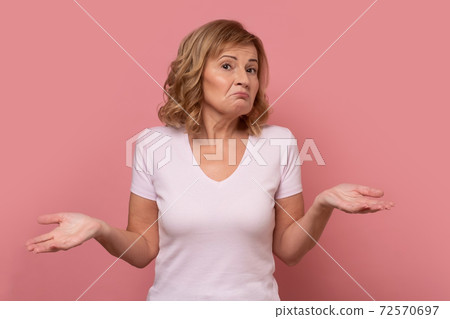 Clueless mature woman shrugging helpless with her shoulders. Clueless mature woman shrugging helpless with her shoulders. 72570697