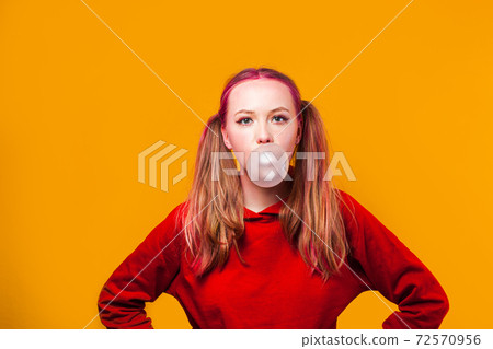 Blowing chewing gum bubbles as showing opposition 72570956