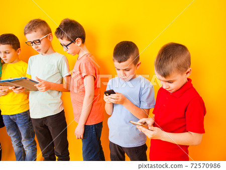 Boys choose their gadgets instead communication with each other Boys choose their gadgets instead communication with each other 72570986