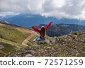 Young woman is sitting on the cliff of the mountain in Sochi, Russia. 72571259
