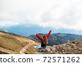 Young woman is sitting on the cliff of the mountain in Sochi, Russia. 72571262