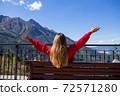Young woman is sitting on bench in Sochi with mountain view on the background, Russia. 72571280