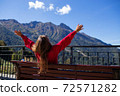 Young woman is sitting on bench in Sochi with mountain view on the background, Russia. 72571282
