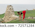 Pretty woman is wearing sportive clothes doing yoga exercises in the park. 72571284