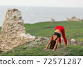 Pretty woman is wearing sportive clothes doing yoga exercises in the park. 72571287