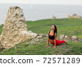 Pretty woman is wearing sportive clothes doing yoga exercises in the park. 72571289