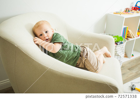 Getting cosy in mum's favourite comfortable armchair Getting cosy in mum's favourite comfortable armchair 72571338