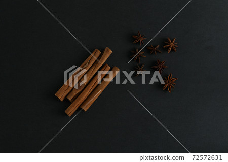 Cinnamon sticks and anise stars flatlay on black background 72572631