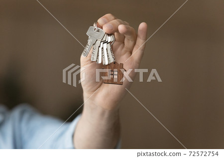 Close up of man buyer show house keys to home Close up of man buyer show house keys to home 72572754