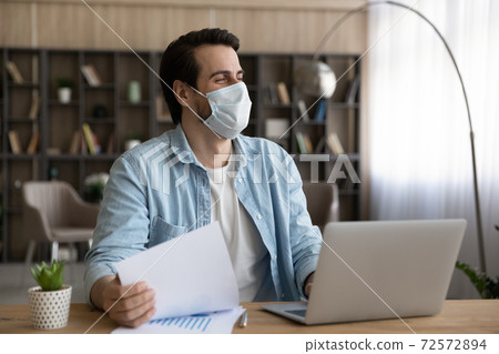 Happy man in facemask work on computer dreaming 72572894