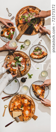 Various pizzas, lemon drinks and peoples hands Various pizzas, lemon drinks and peoples hands 72573372