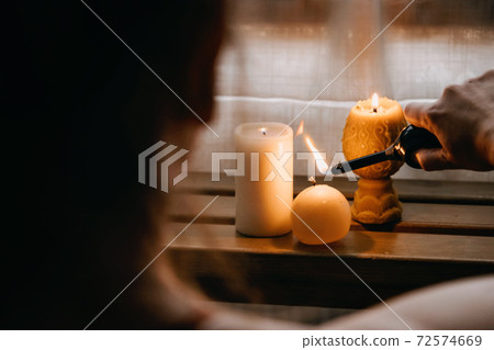 Young woman sitting on the floor, lights candles, enjoy meditation, do yoga exercise at home. Mental health, self care, No stress, healthy habit, mindfulness lifestyle, anxiety relief concept Young woman sitting on the floor, lights candles, enjoy meditation, do yoga exercise at home. Mental health, self care, No stress, healthy habit, mindfulness lifestyle, anxiety relief concept 72574669