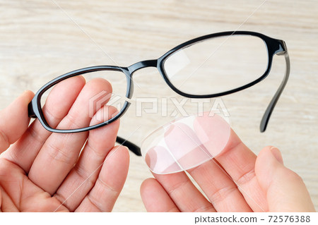 Hands hold eyeglasses with broken rim and fallen out lens. Hands hold eyeglasses with broken rim and fallen out lens. 72576388