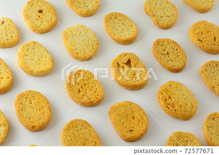 Italian black pepper and prosciutto ham flavored bread bites in a row on white background Italian black pepper and prosciutto ham flavored bread bites in a row on white background 72577671
