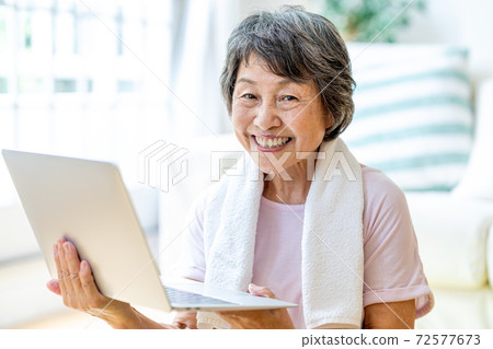 Senior woman exercising in the living room 72577673
