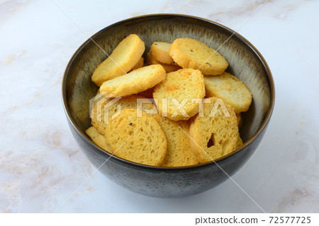 Italian black pepper and prosciutto ham flavored bread bites in ceramic bowl on table Italian black pepper and prosciutto ham flavored bread bites in ceramic bowl on table 72577725