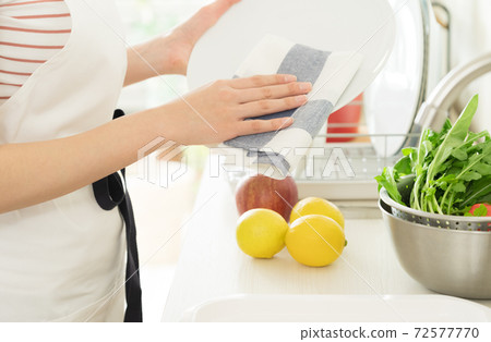 Hands of a woman doing housework in the kitchen Hands of a woman doing housework in the kitchen 72577770