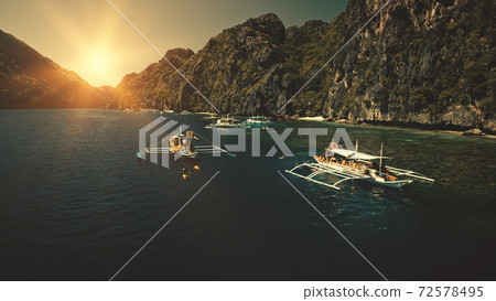 Seascape with passenger boats at sunset in closeup aerial view. Cliff coast with trees at sun summer 72578495