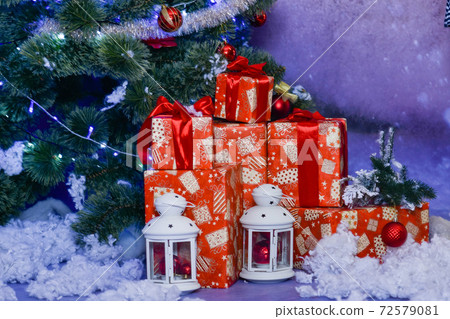 Christmas gifts under the Christmas tree with retro lanterns on a blue background in the Studio Christmas gifts under the Christmas tree with retro lanterns on a blue background in the Studio 72579081