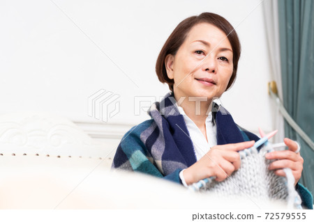 A woman who babysits while knitting 72579555