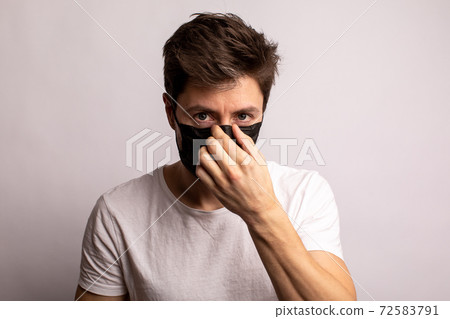 studio shot of a young man wearing a black mask, looking at camera, isolated on white background studio shot of a young man wearing a black mask, looking at camera, isolated on white background 72583791