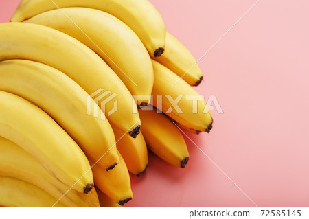 Fresh bunch of yellow bananas isolated on a pink background. Fresh bunch of yellow bananas isolated on a pink background. 72585145
