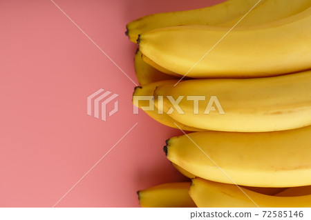 A bunch of ripe Yellow Bananas on a Pink Background. A bunch of ripe Yellow Bananas on a Pink Background. 72585146