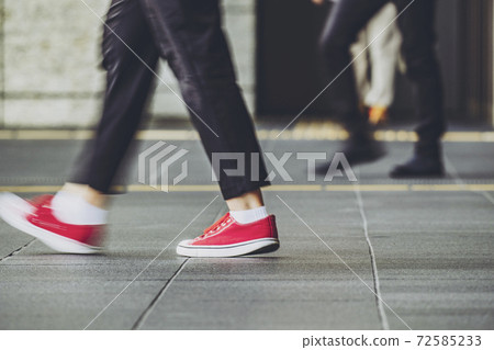 The feet of a walking person 72585233