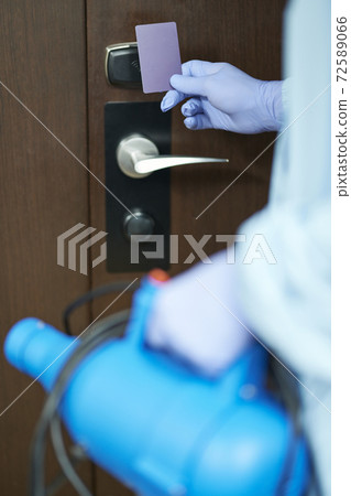 Worker using card to open an electronic lock on a hotel door Worker using card to open an electronic lock on a hotel door 72589066