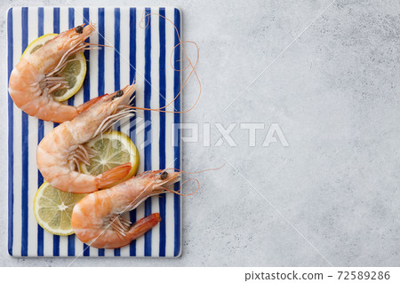 Cooked tiger prawns on striped plate Cooked tiger prawns on striped plate 72589286