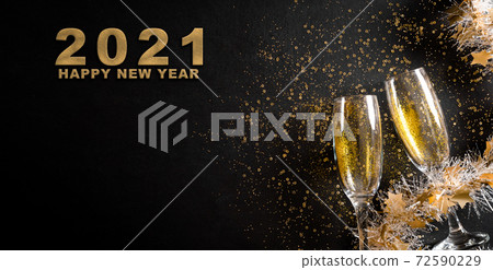 Christmas and New Year holidays background concept made from champagne glasses with golden glitter on black wooden background. Christmas and New Year holidays background concept made from champagne glasses with golden glitter on black wooden background. 72590229
