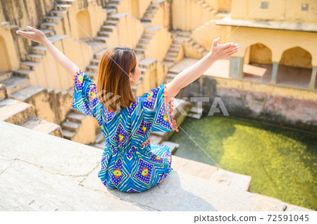 Portrait of young woman traveling in India step-well at Jaipur in Rajasthan state, India Portrait of young woman traveling in India step-well at Jaipur in Rajasthan state, India 72591045