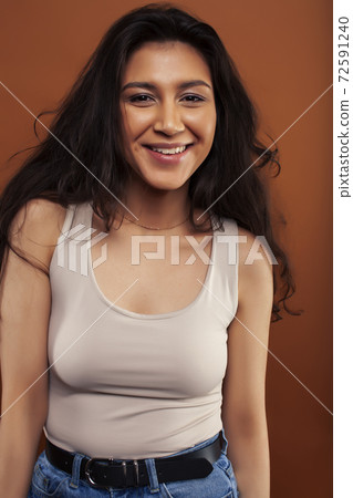 young pretty girl with curly hair posing cheerful on brown background, lifestyle people concept young pretty girl with curly hair posing cheerful on brown background, lifestyle people concept 72591240