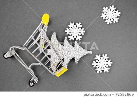 Christmas decorations snowflakes and Christmas tree fall from a small toy cart. Yellow and gray. Color trend of 2021. Happy New Year. Christmas decorations snowflakes and Christmas tree fall from a small toy cart. Yellow and gray. Color trend of 2021. Happy New Year. 72592669
