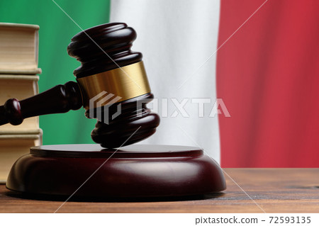 Justice and court concept in Italian Republic. Judge hammer on a Italy flag background Justice and court concept in Italian Republic. Judge hammer on a Italy flag background 72593135