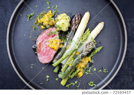 dry aged sliced fillet steak with green, white and lilac asparagus  72593437