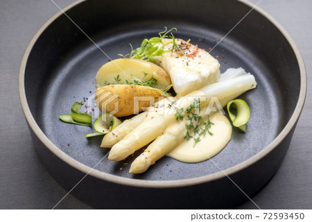 German fried cod fish filet with white asparagus in sauce hollandaise und roast potatoes German fried cod fish filet with white asparagus in sauce hollandaise und roast potatoes 72593450