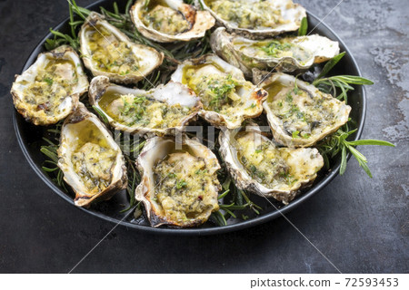 Traditional barbecue overbaked fresh opened oyster with garlic and herbs Traditional barbecue overbaked fresh opened oyster with garlic and herbs 72593453