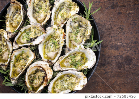 Traditional barbecue overbaked fresh opened oyster with garlic and herbs Traditional barbecue overbaked fresh opened oyster with garlic and herbs 72593456