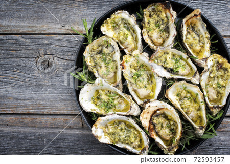 Traditional barbecue overbaked fresh opened oyster with garlic and herbs Traditional barbecue overbaked fresh opened oyster with garlic and herbs 72593457