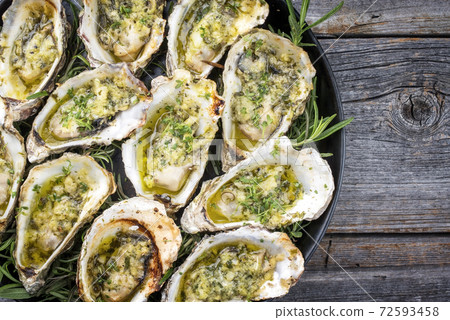 Traditional barbecue overbaked fresh opened oyster with garlic and herbs Traditional barbecue overbaked fresh opened oyster with garlic and herbs 72593458