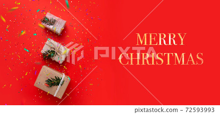 three boxes with gifts on bright red background and inscription Merry Christmas 72593993