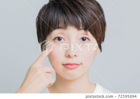 指著她的眼睛的年輕女子 72595894