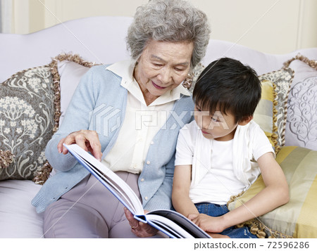 grandma and grandson reading a book together 72596286