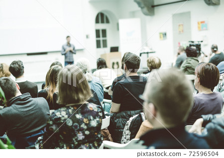 Man giving presentation in lecture hall at university. Man giving presentation in lecture hall at university. 72596504
