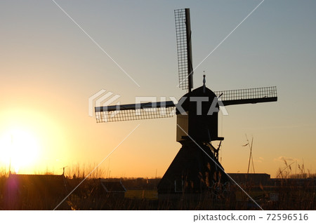 Windmill standing towards the setting sun 72596516