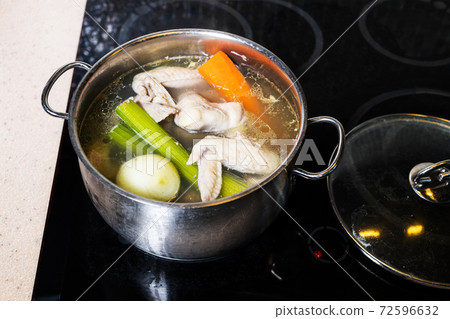 above view of chicken broth in stewpot on stove above view of chicken broth in stewpot on stove 72596632