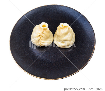 two cooked Buuz dumplings on dark plate isolated 72597026