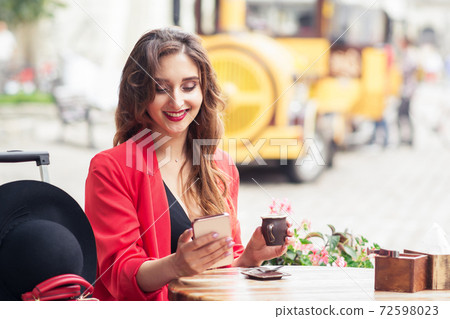 Woman looks in smartphone. 72598023