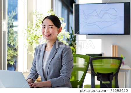 Business woman working on a computer in a bright office 72598430